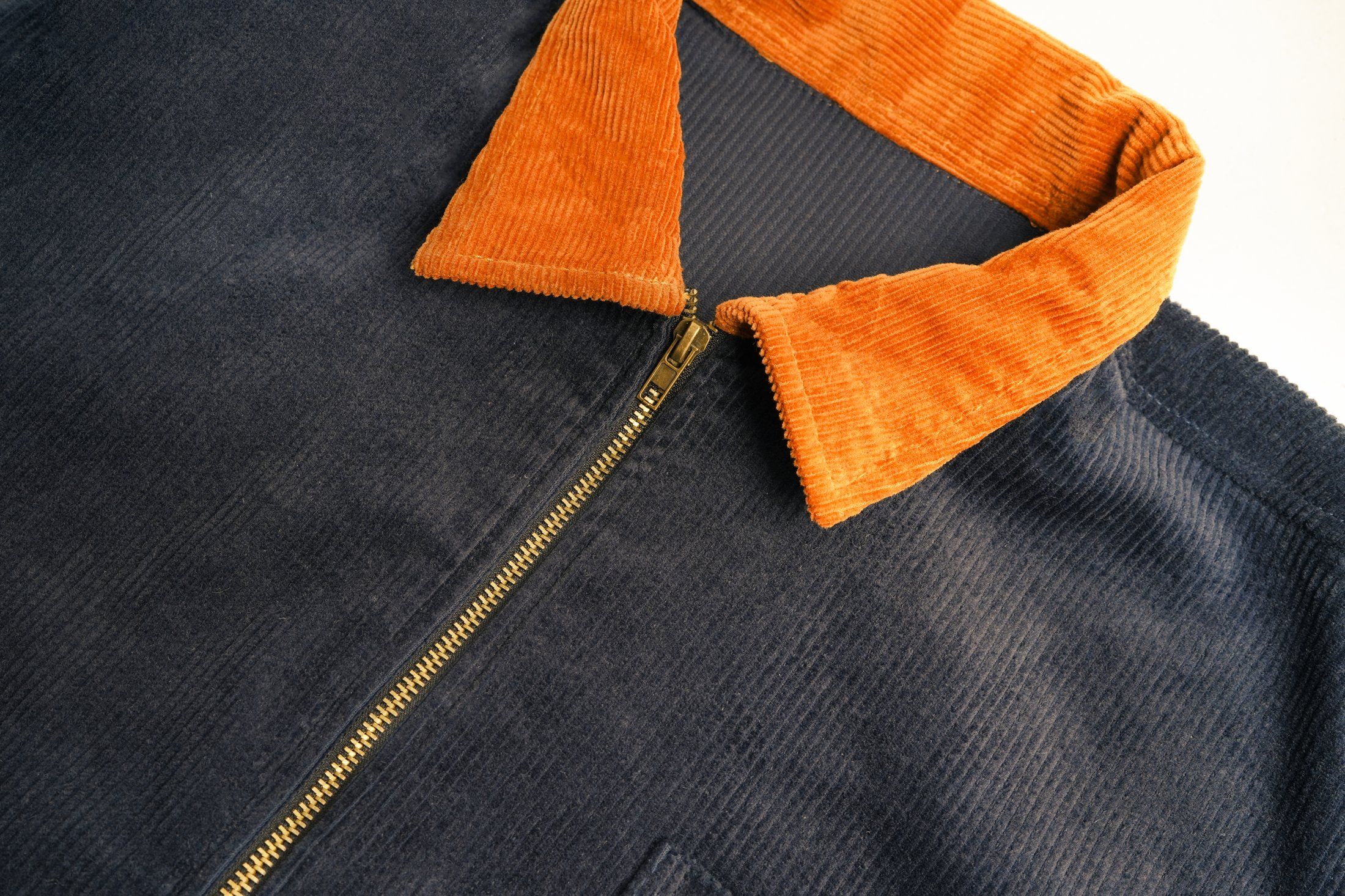 Corduroy collar and brass zip in close-up
