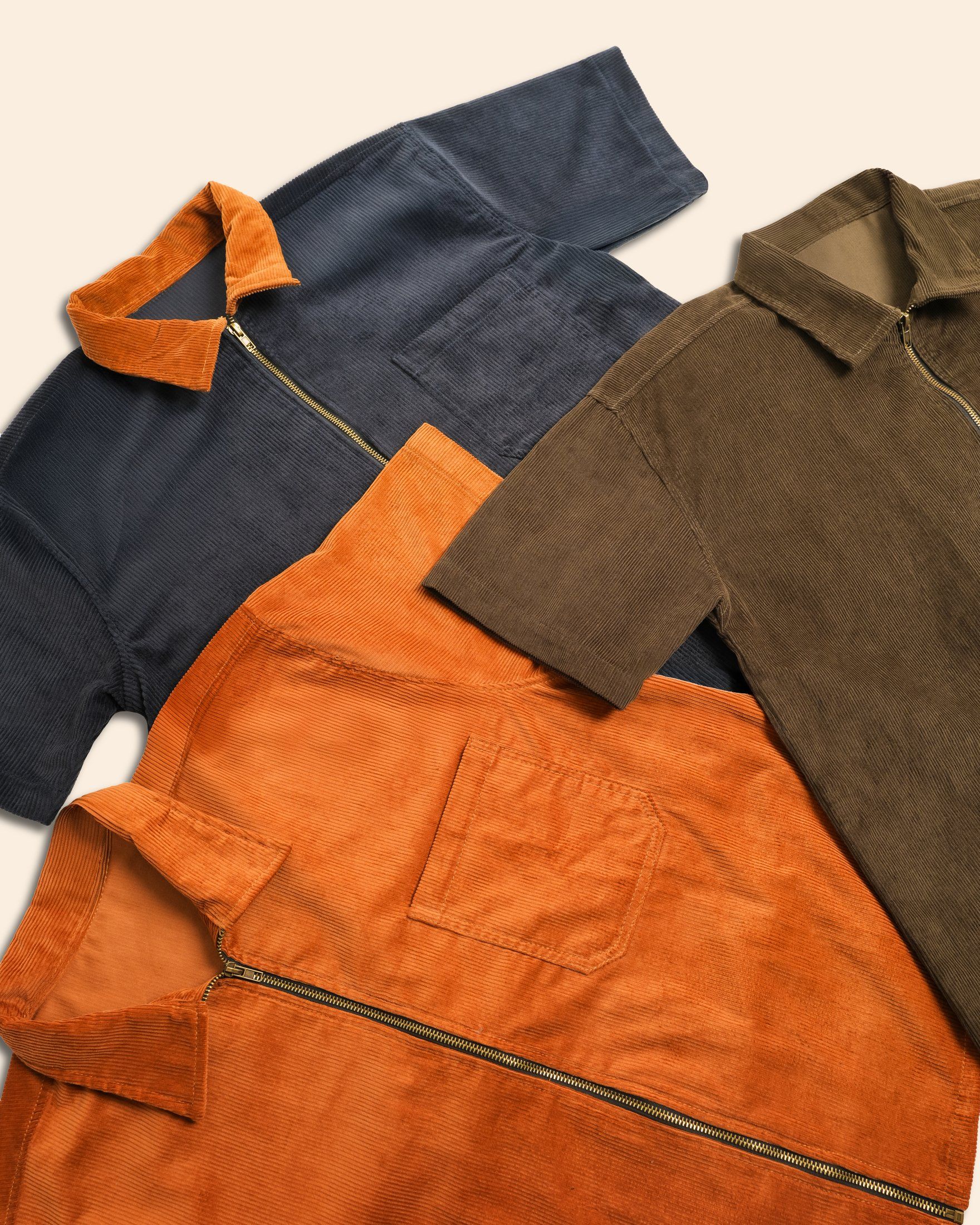 The boxy corduroy workshirt laid flat in navy, rust and olive